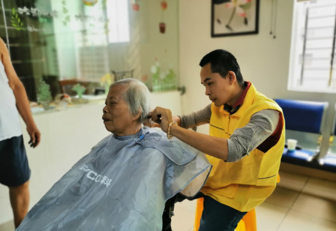 工作人员在给老人理发